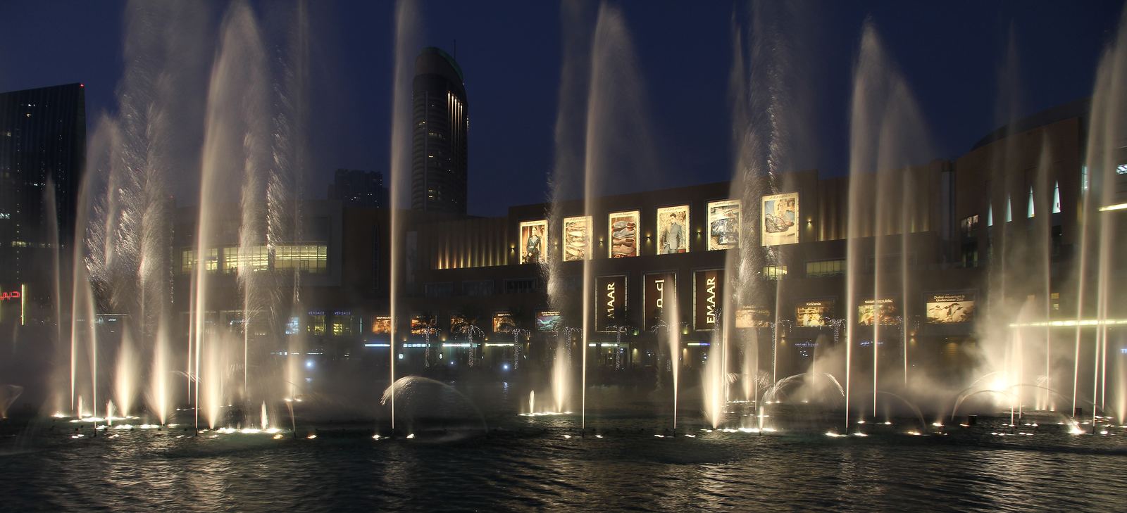 The Dubai Fountain at dusk with Downtown Dubai behind it